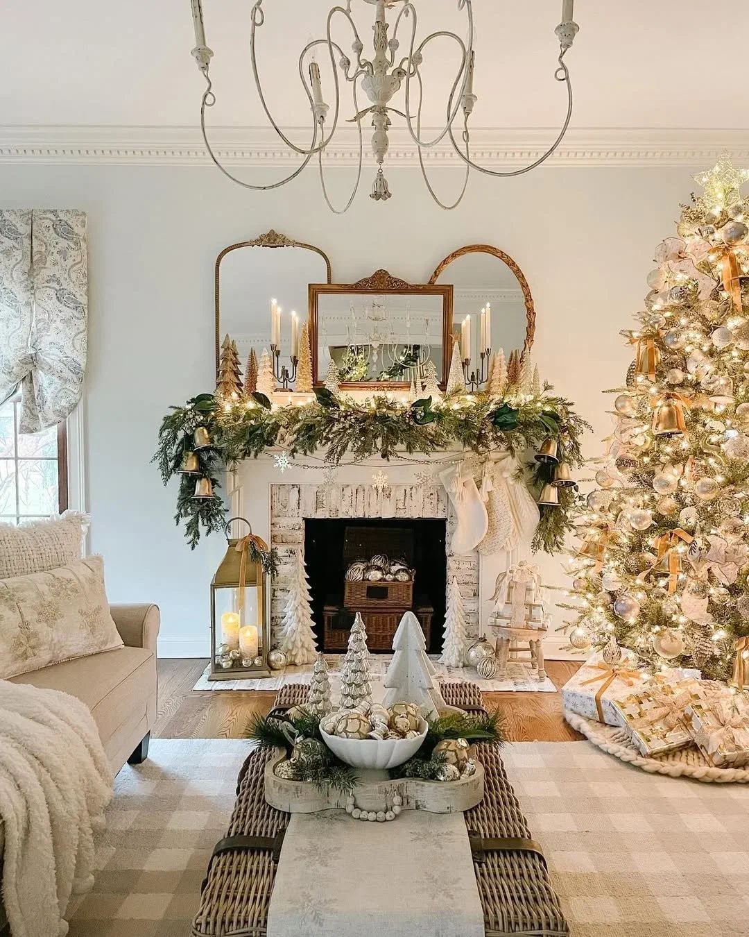 Fresh greenery garland draped along a mantel above a fireplace, styled with mini trees and candlelight