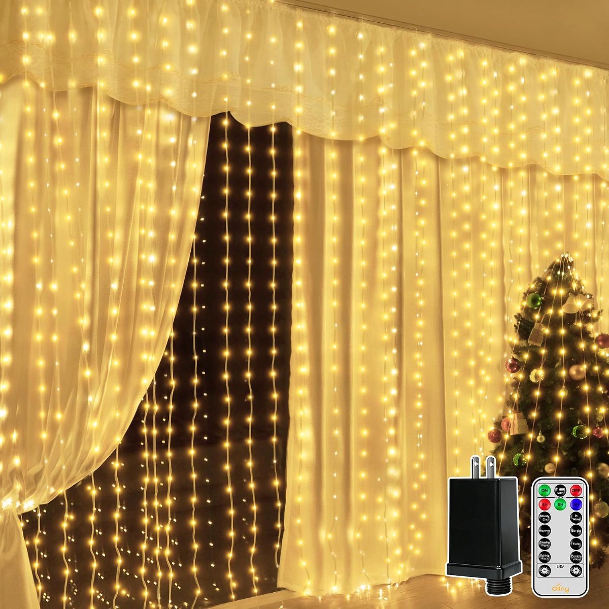 Ollny curtain lights covering a large window behind sheer curtains, with a Christmas tree and remote in frame